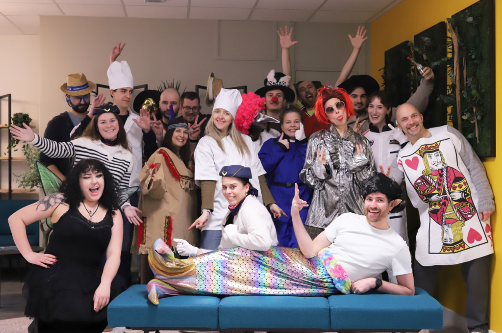 Groupe d'adultes souriant lors d'un événement mutuelle santé, costumes colorés, protection sociale.