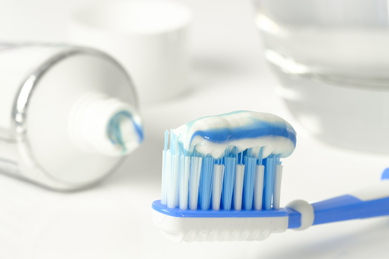 Brosse à dents avec dentifrice près d'un tube mutuelle santé, symbolisant protection et complémentaire santé.