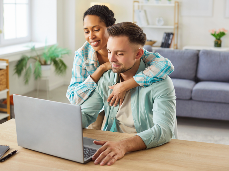 Couple réalisant un devis de mutuelle santé en ligne depuis son domicile sur un ordinateur portable.