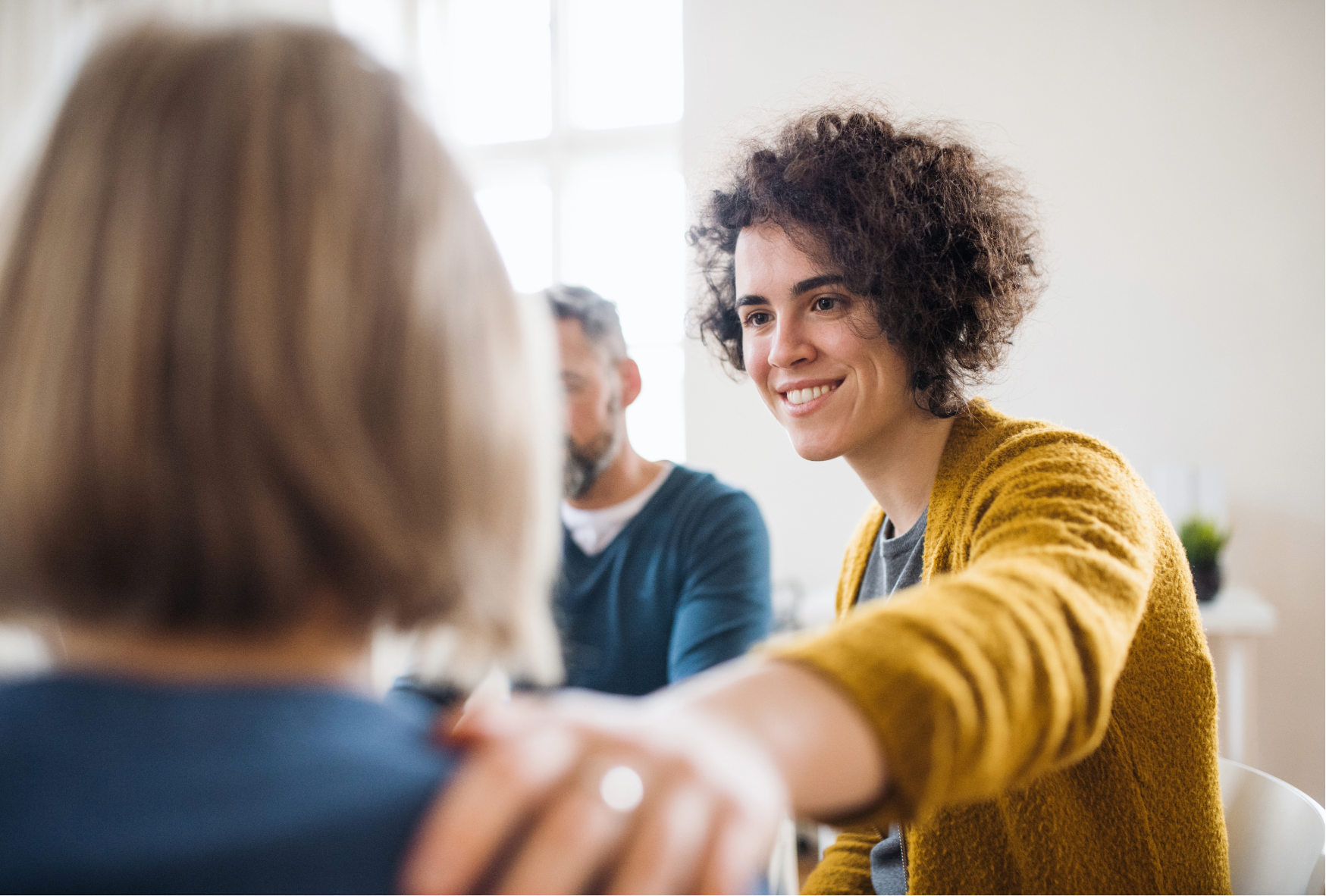 Personnes participant à un échange dans un environnement intérieur, illustrant le bien-être et la qualité de l'air dans les espaces de vie et de travail.